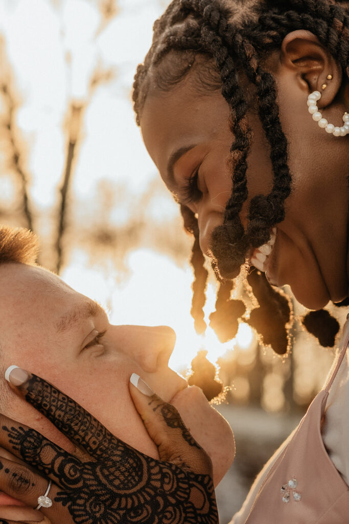 The sun flares through a couple as they embrace