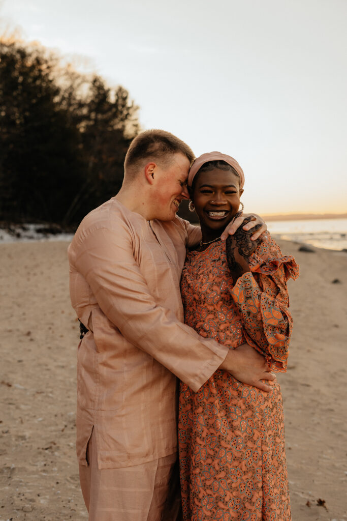 An engaged couple cuddles into each other at Mission Point Lighthouse 