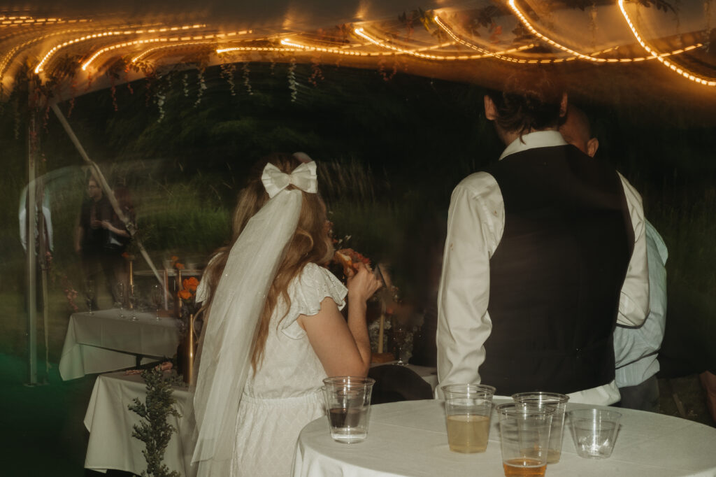 A couple enjoys late night pizza at their wedding reception