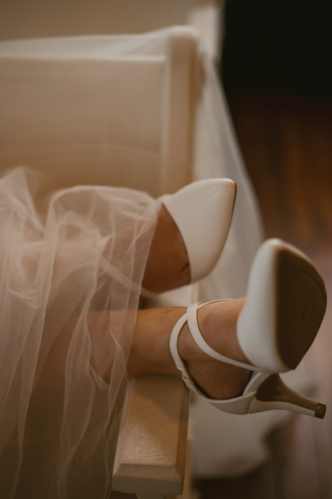 A bride's shoes are kicked over the church pew at her intimate micro wedding in Michigan. 