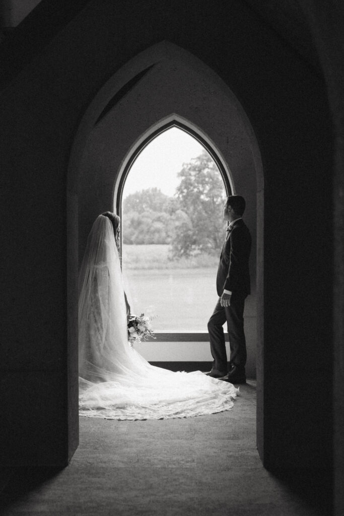 bride and groom look out the window together