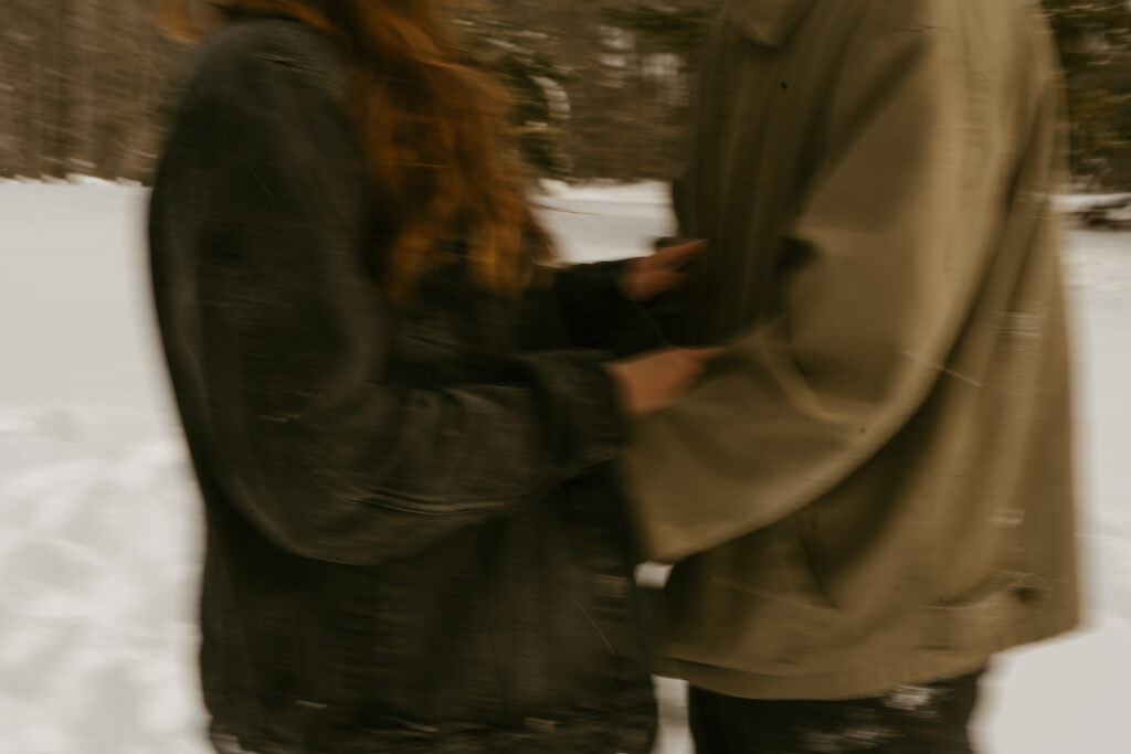 couple cuddles together for their winter engagement session