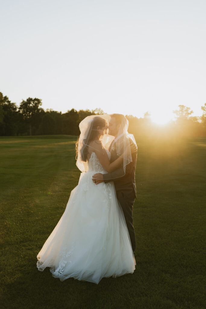 Bride and groom embrace during sunset bridal photo