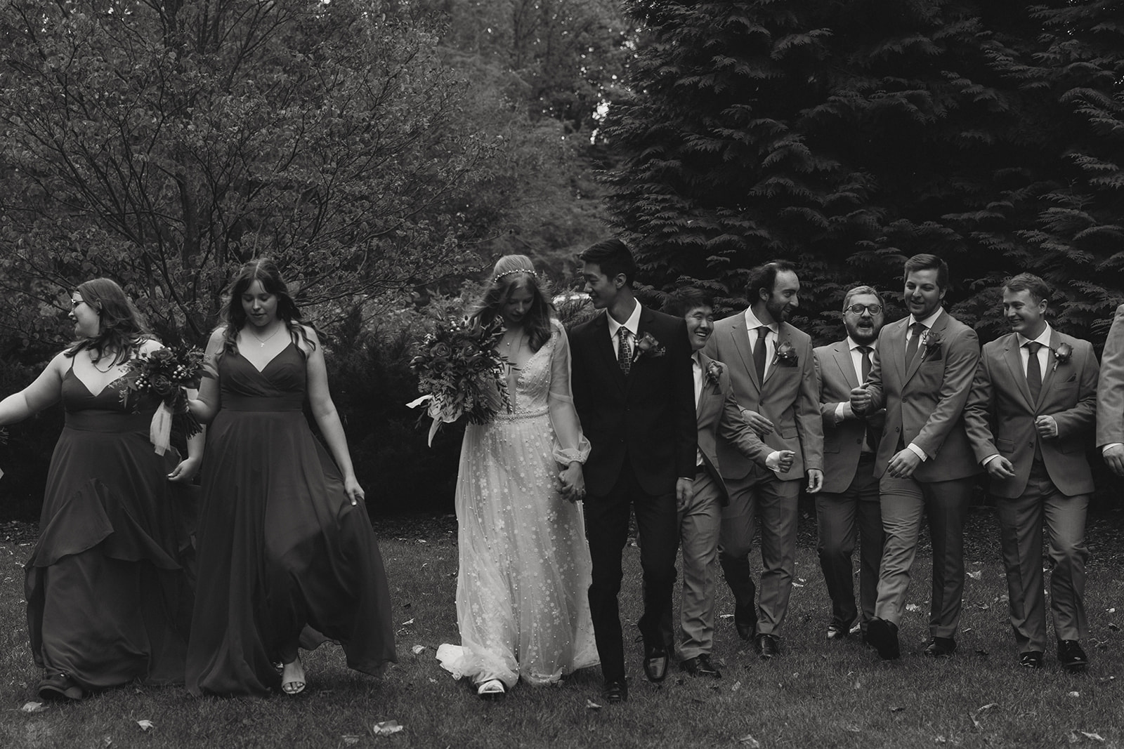 bride and groom walk with their wedding party as they head towards the reception 