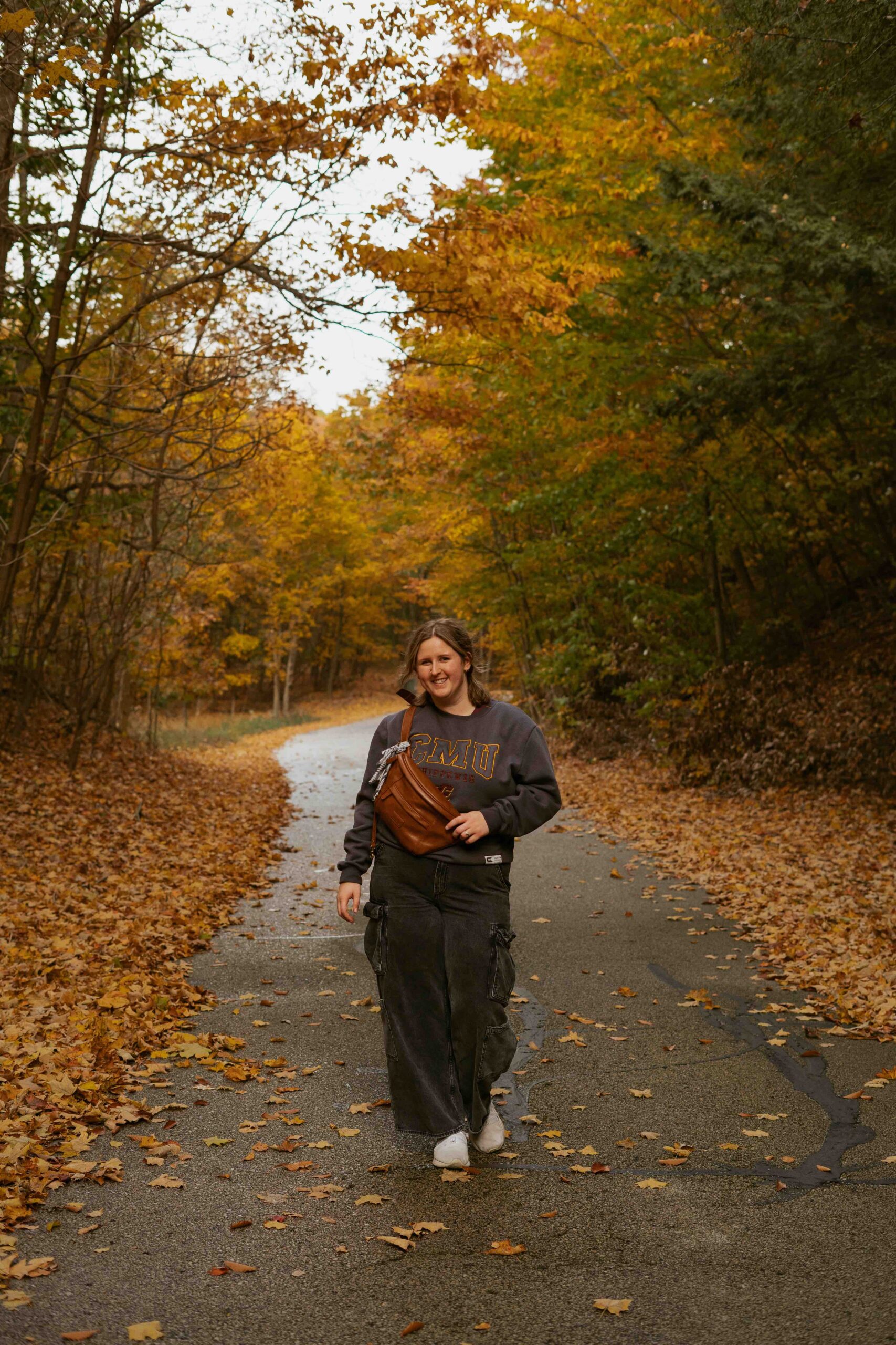 Gabrielle Cynthia poses for a photo in Fall foliage tree tunnel