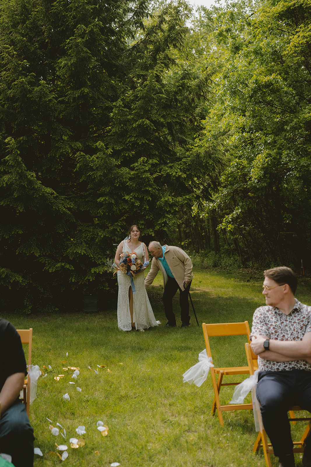 bride and her grandpa enter the stunning wedding ceremony in the backyard