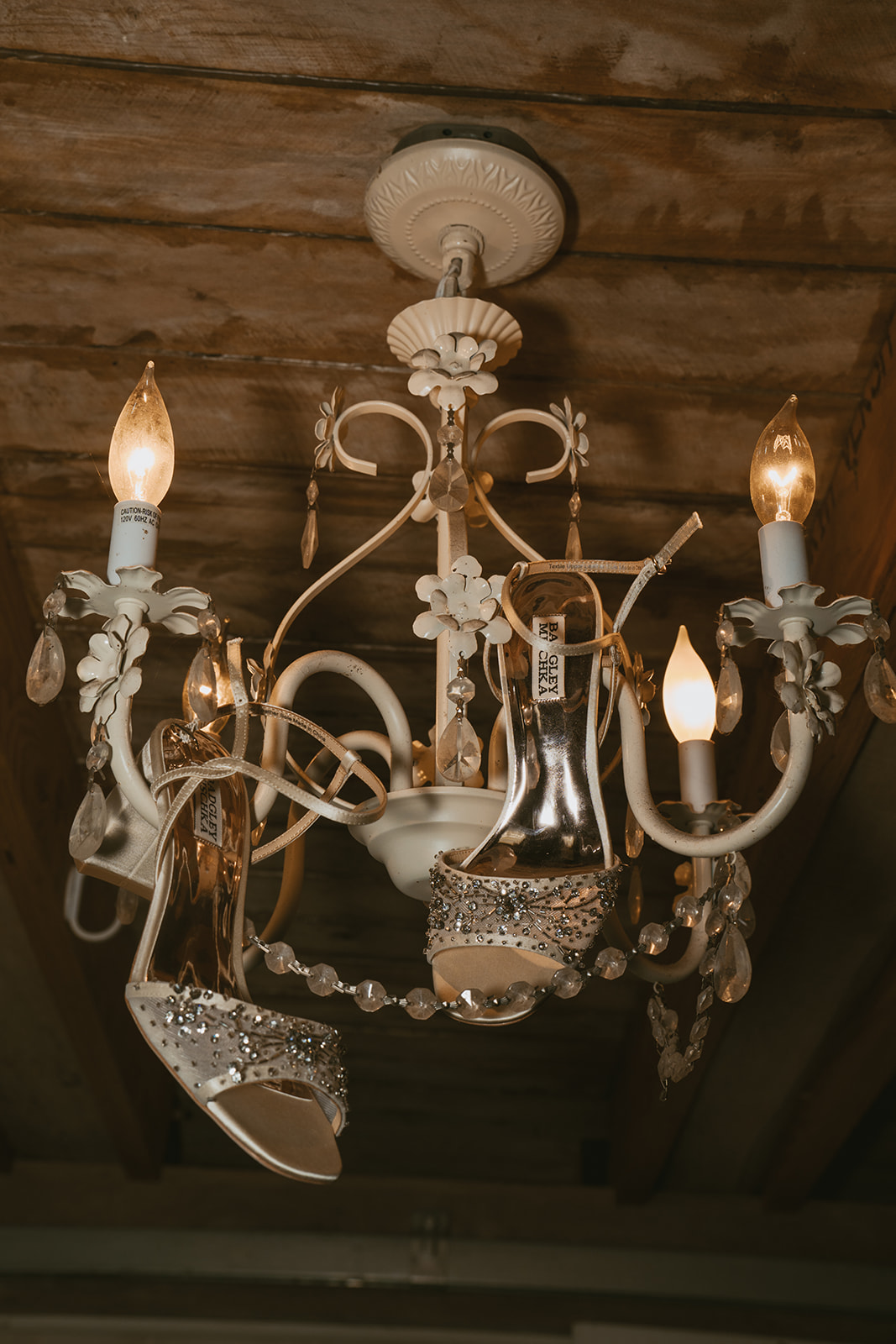 brides shoes hang on the chandelier before her stunning Michigan elopement ceremony