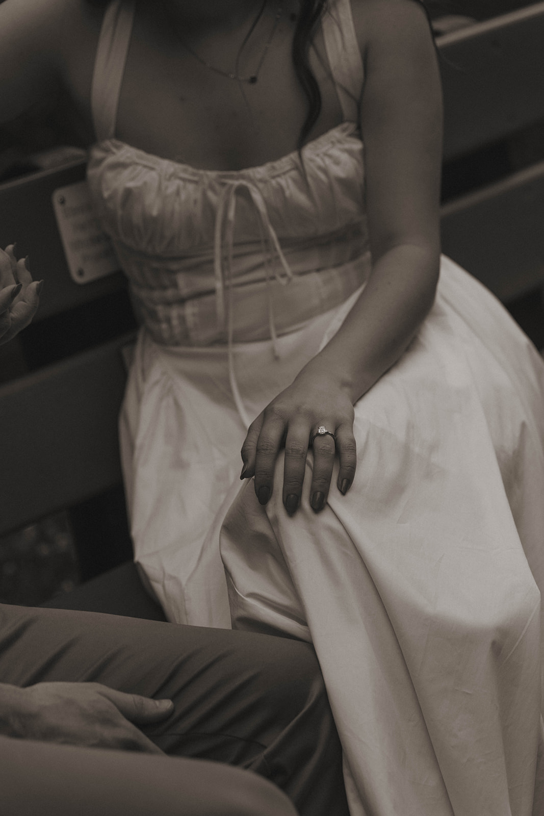 couple pose together on a park bench in Grand Rapids for their engagement session