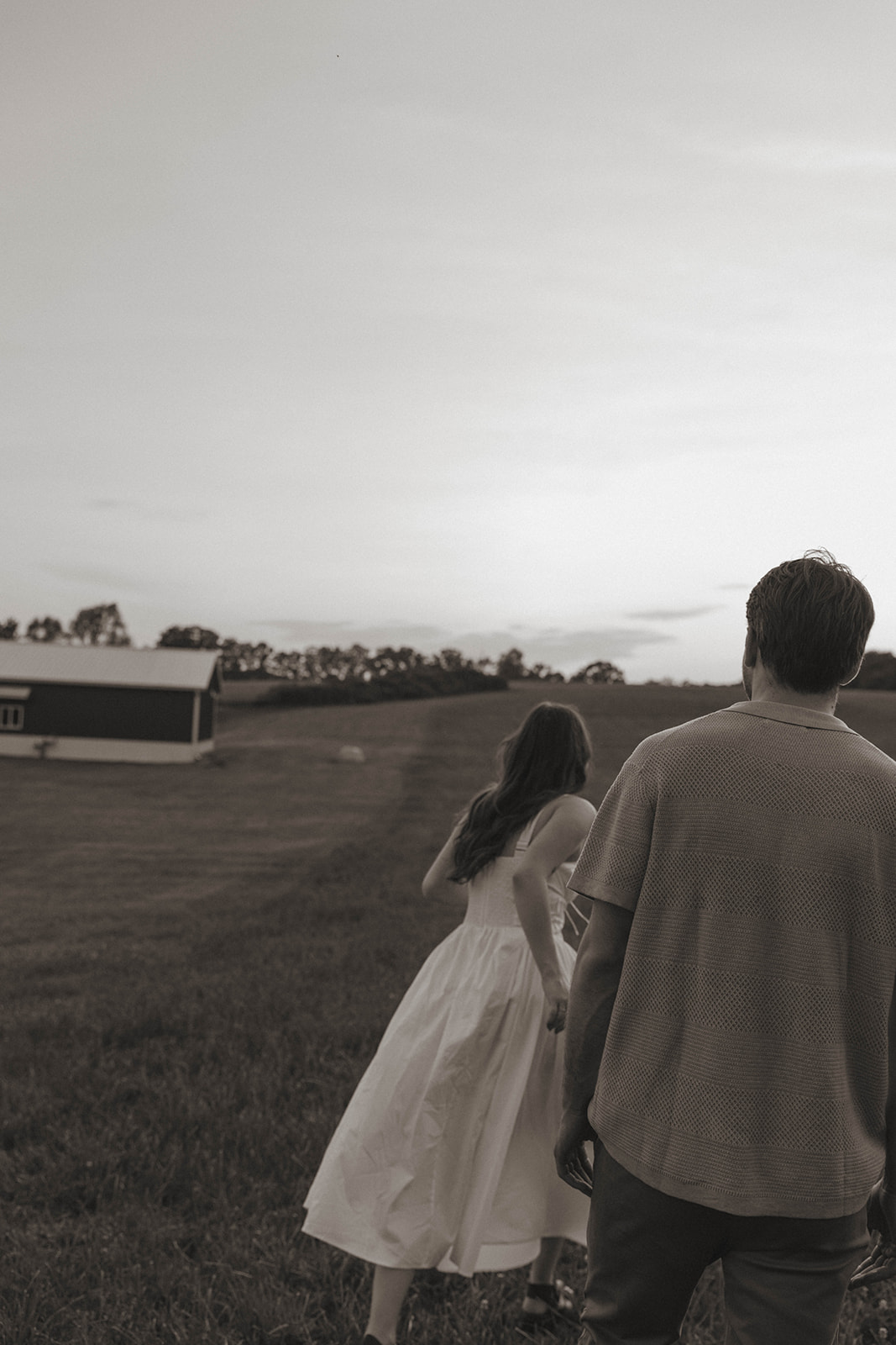 beautiful couple run through a Michigan field at golden hour