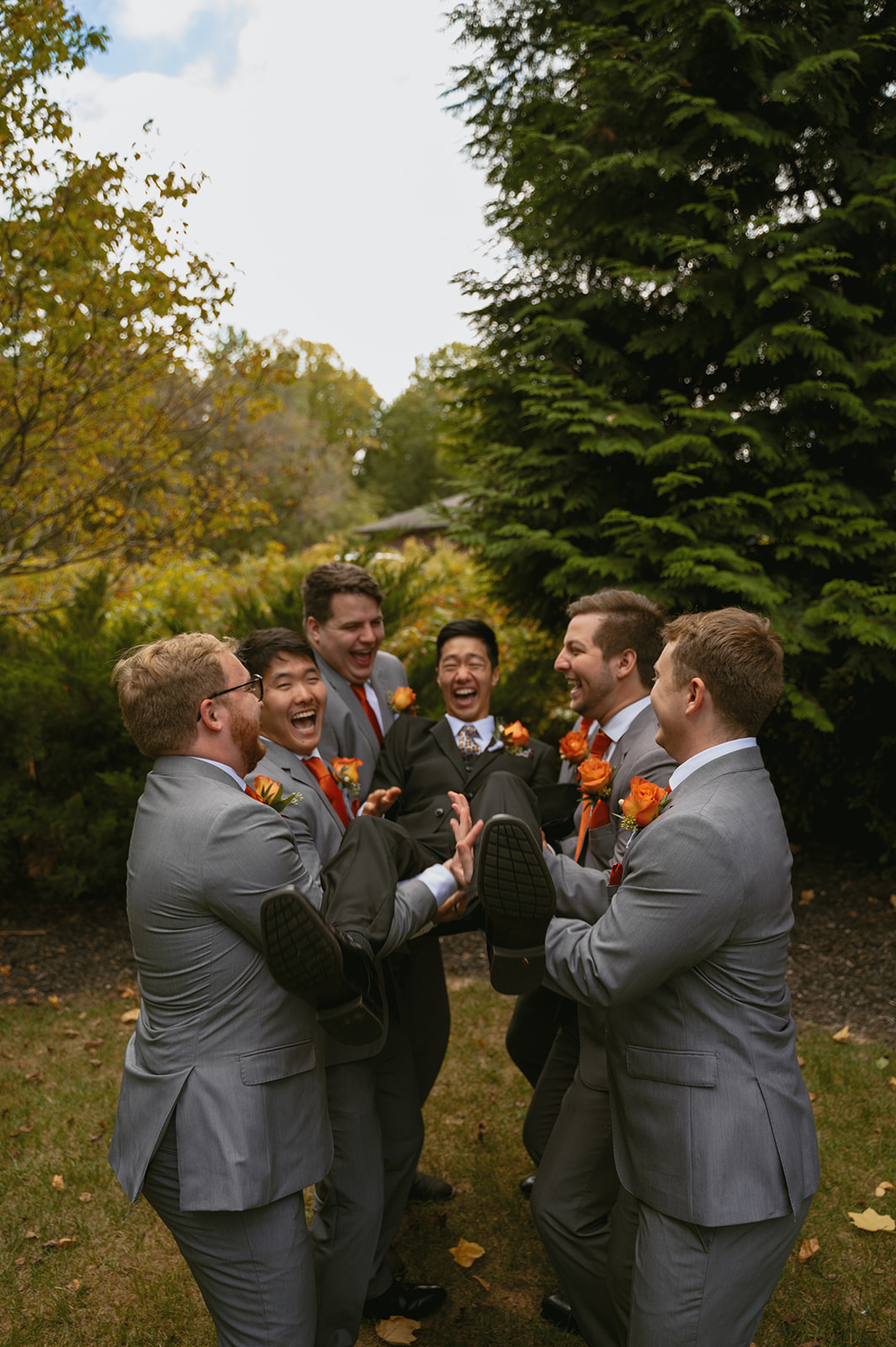 groom gets carried by his groomsmen