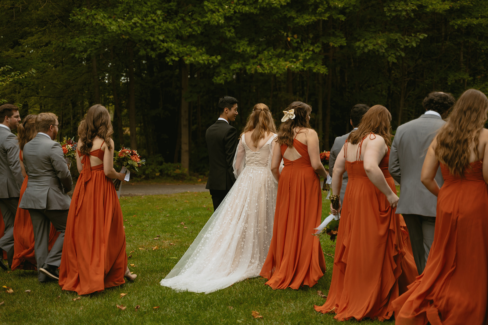 wedding party walks towards their photo session during their fall wedding timeline
