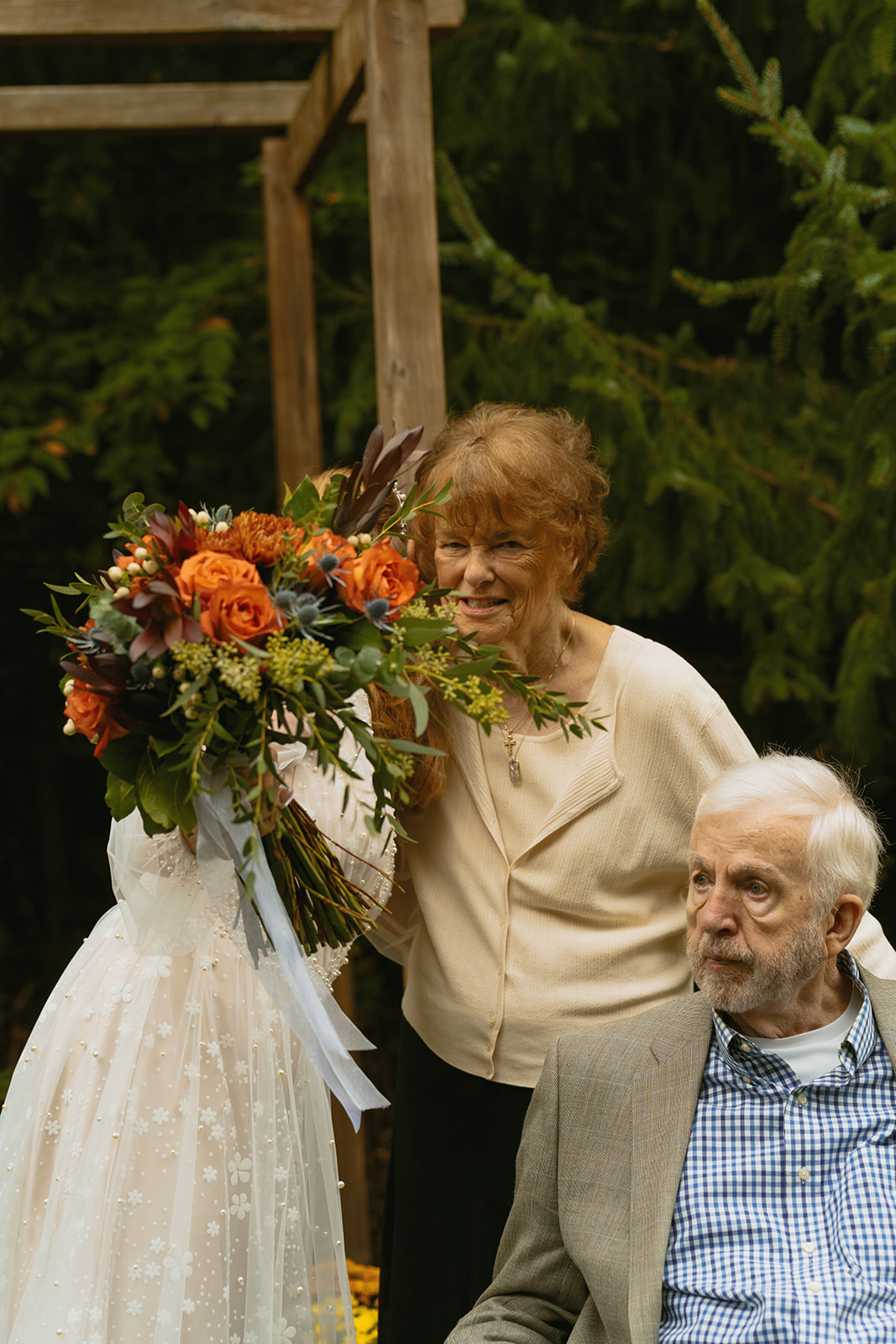 bride and her grandparents pose for a photo together, schedule some family photo time into your fall wedding day timeline!