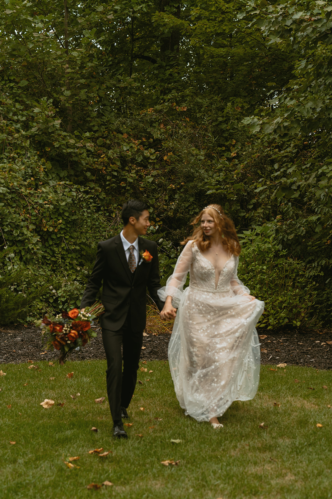 stunning bride and groom pose in the forest together during their fall wedding!