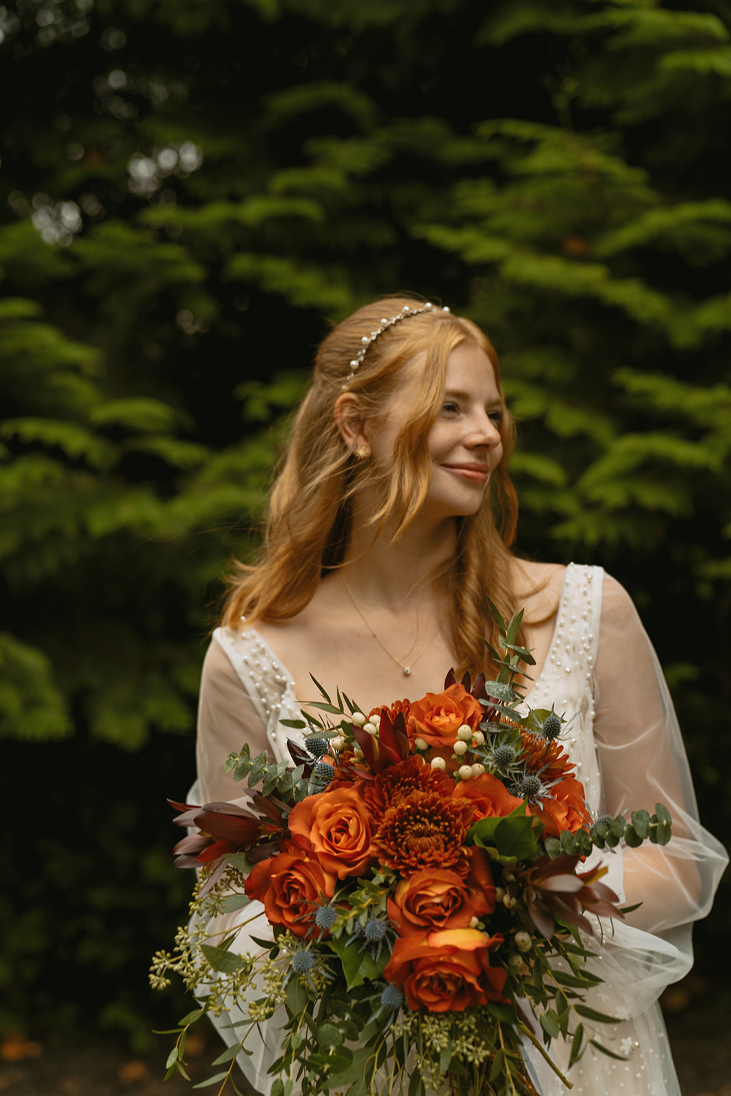 beautiful bride poses with her bouquet after her fall wedding day