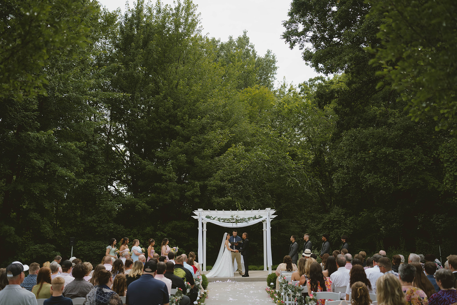 beautiful wedding ceremony takes place under overcast clouds