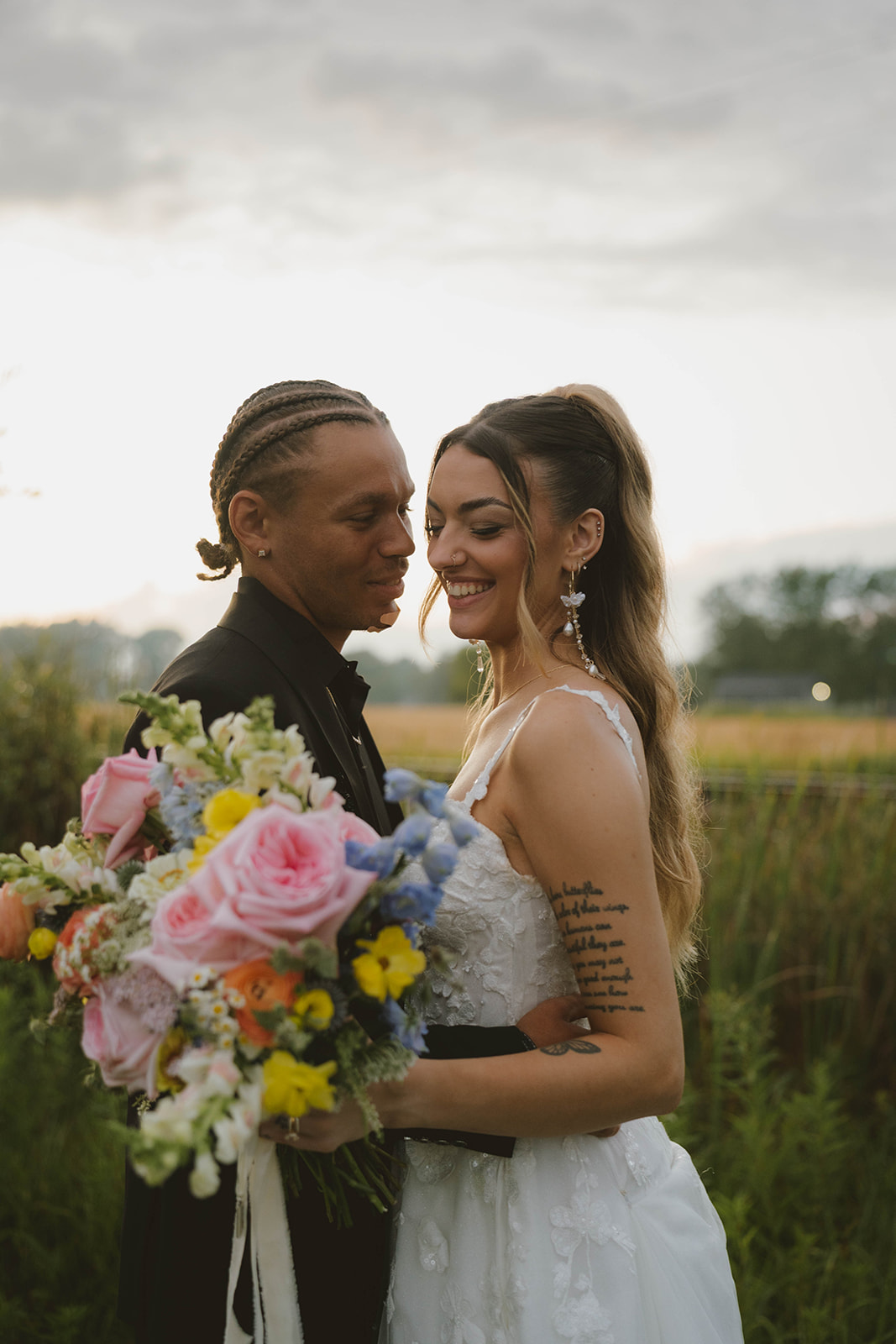 stunning bride and groom share a laugh together during their outdoor wedding! Learn to weatherproof your outdoor wedding with this blog!