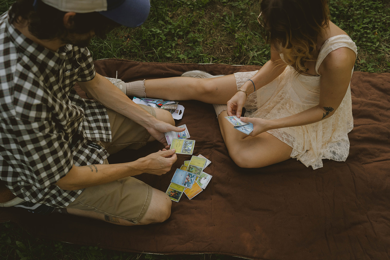 couple go through their pokemon cards they opened during their fun engagement photoshoot