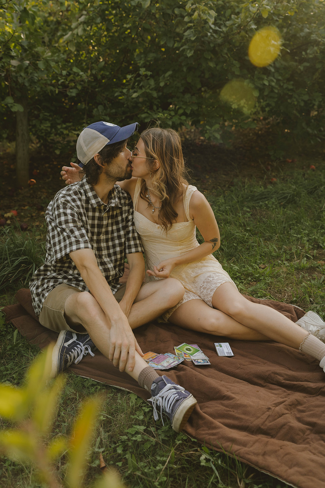stunning couple share a kiss after they open their pack of pokemon cards during their fun engagement photoshoot idea