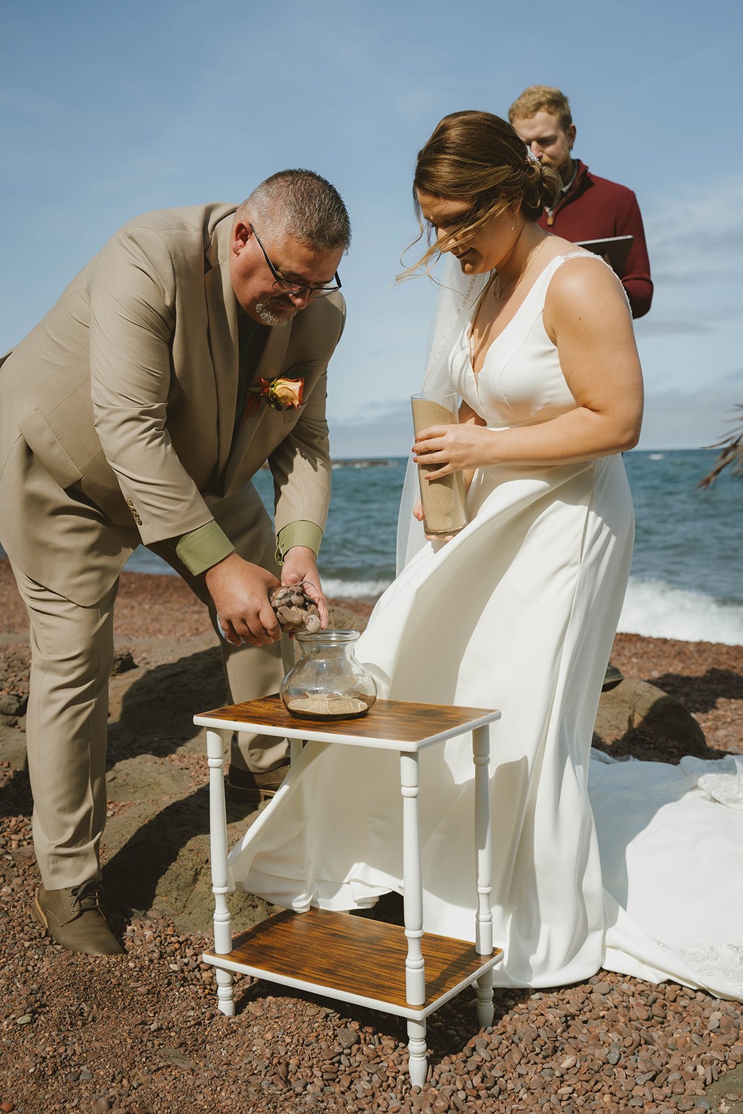 bride and groom make a sand keepsake from the Copper Harbor beach