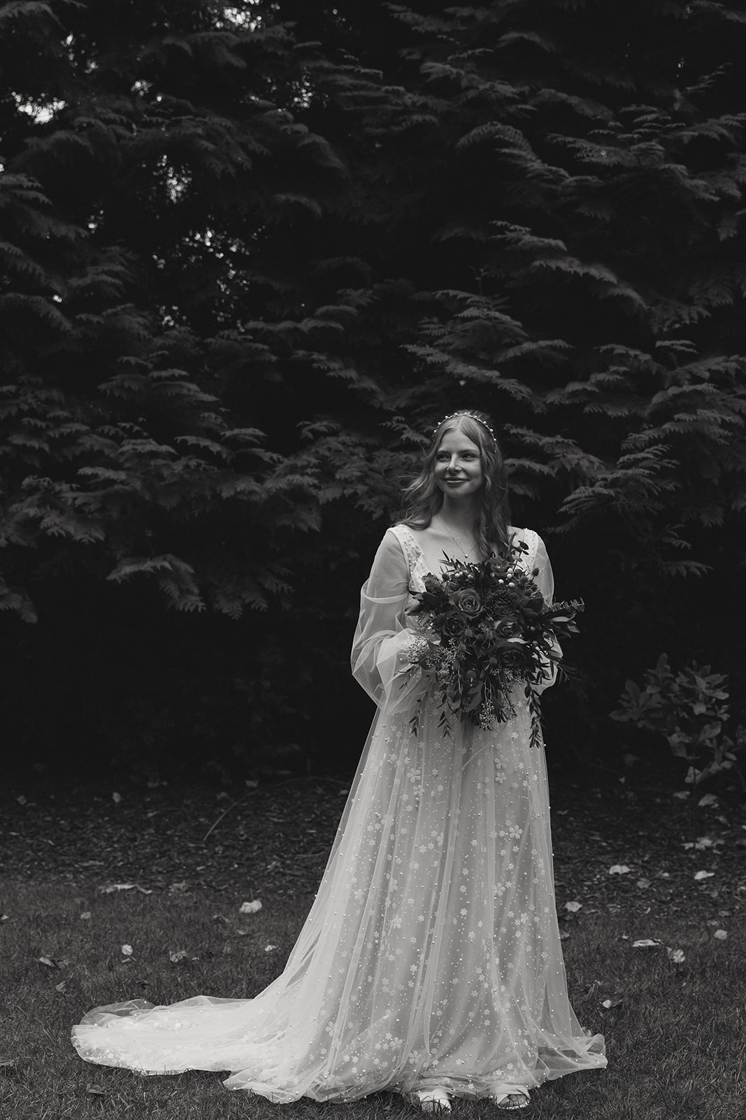 beautiful bride poses for a photo against the Michigan forest in the background