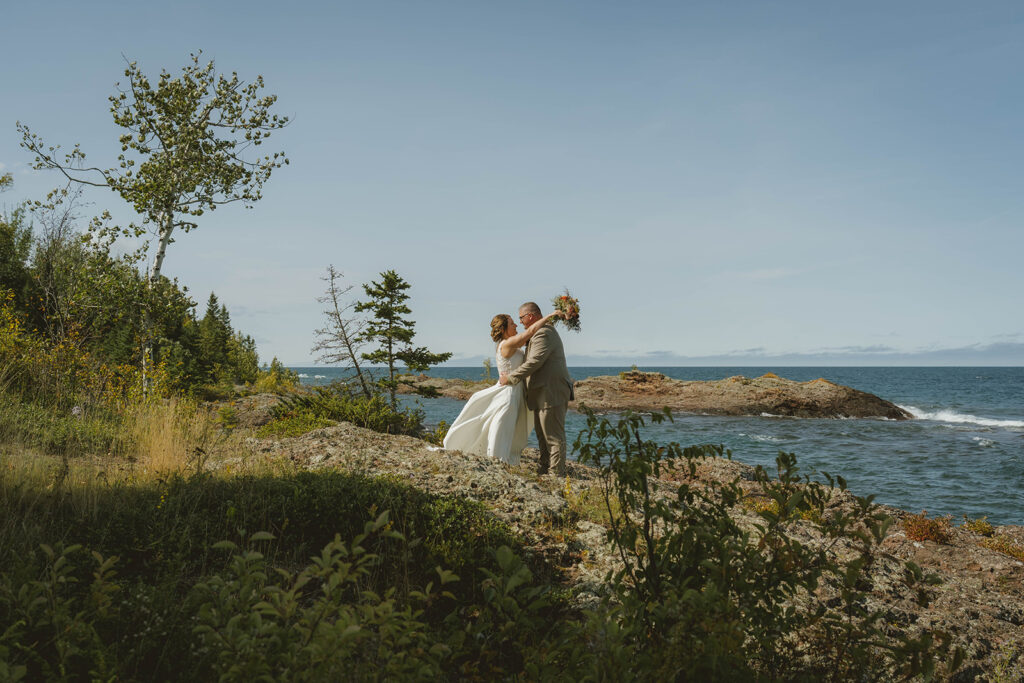 bride and groom share an intimate moment with Copper Harbor in the background