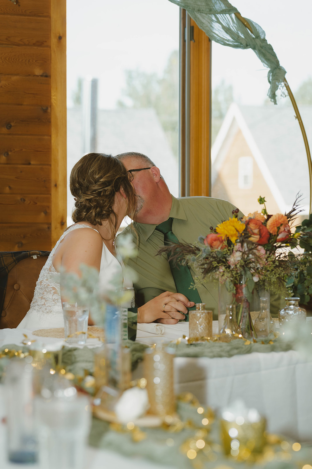 bride and groom share a kiss at their wedding reception