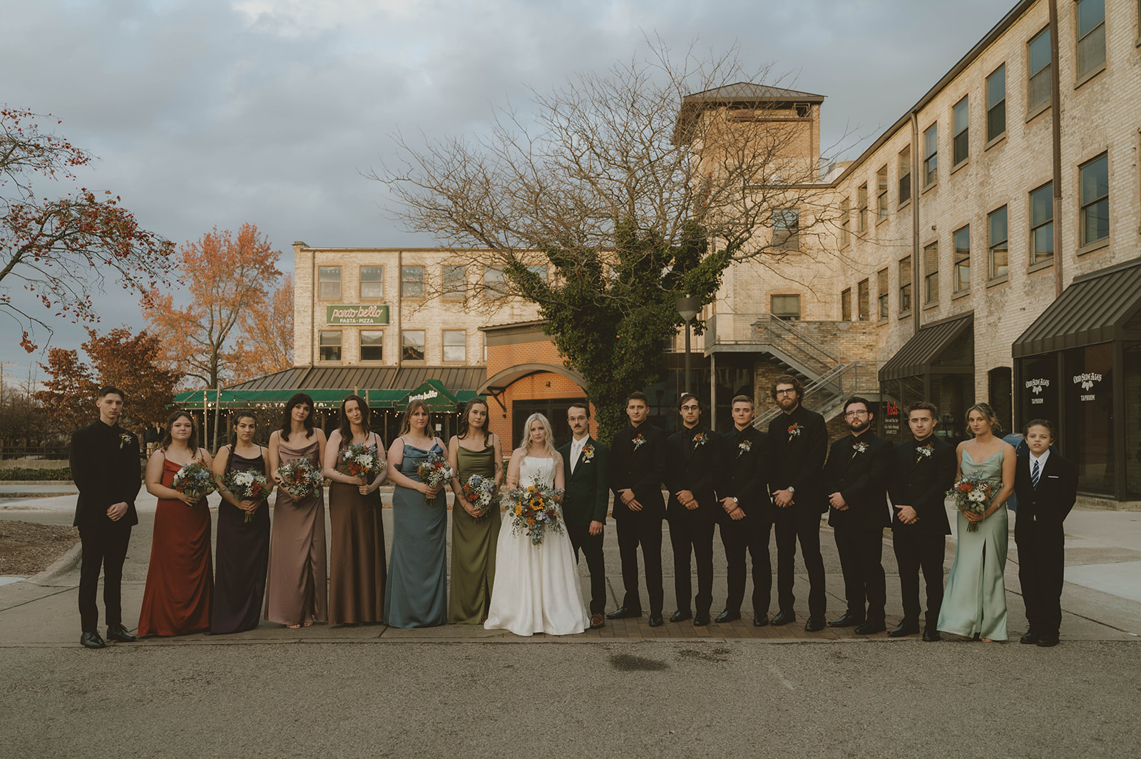 wedding party poses for a photo outside the beautiful wedding venue
