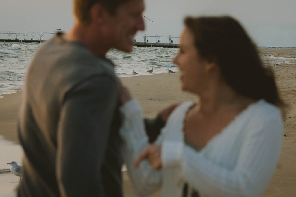 candid photo of a couple laughing, and enjoying their unique beach engagement session