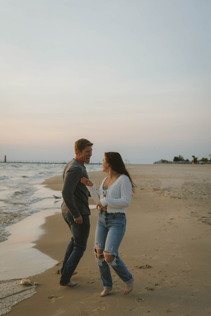 beautiful couple run and laugh on the Lake Michigan beach