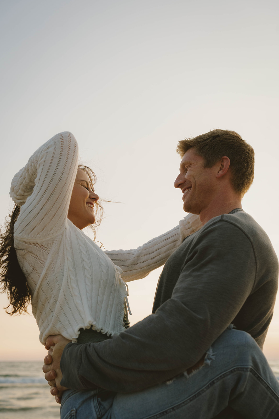 candid photo of a couple laughing, and enjoying their unique beach engagement session