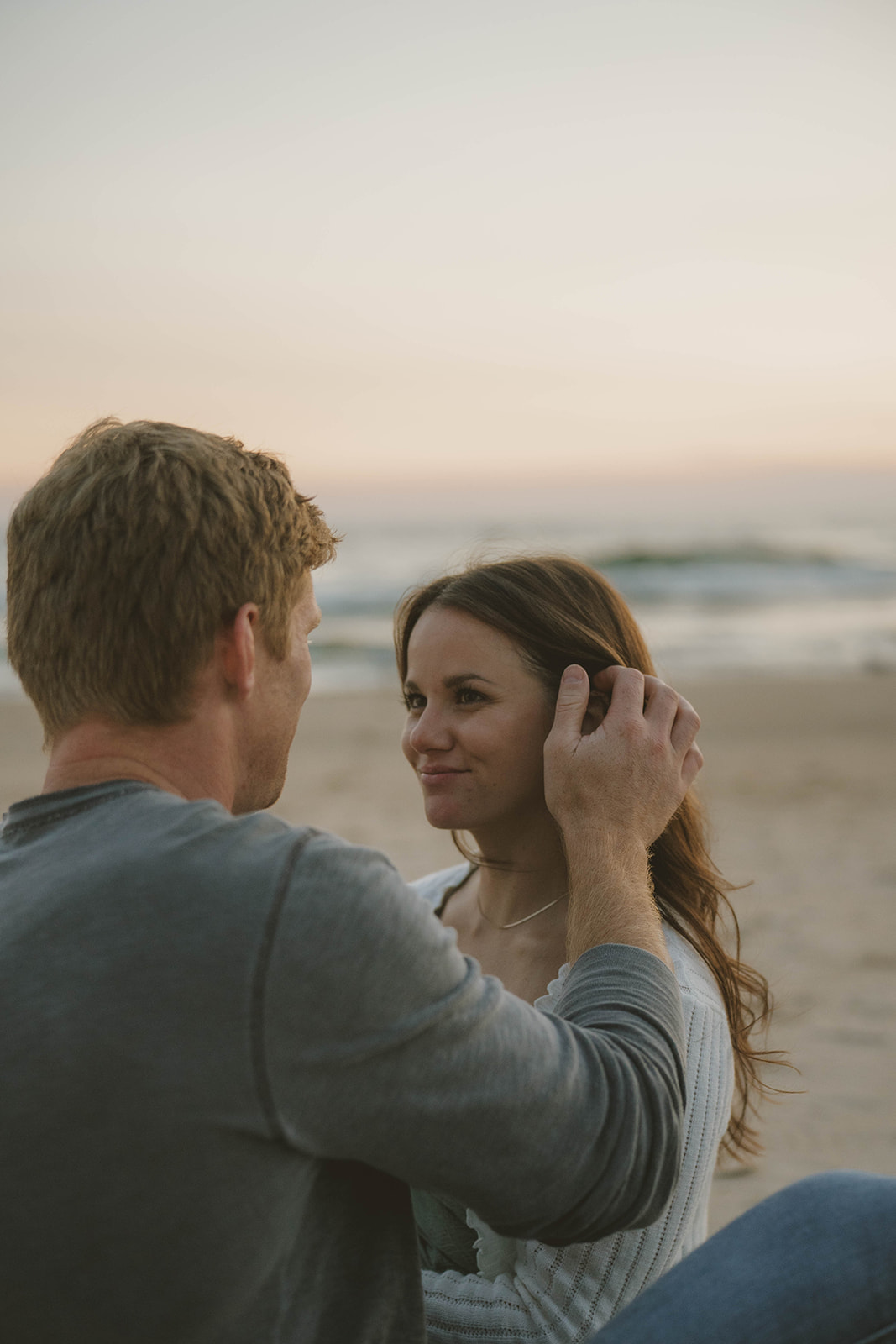 romantic photo captured during a Michigan engagement session with the stunning lake waves in the background