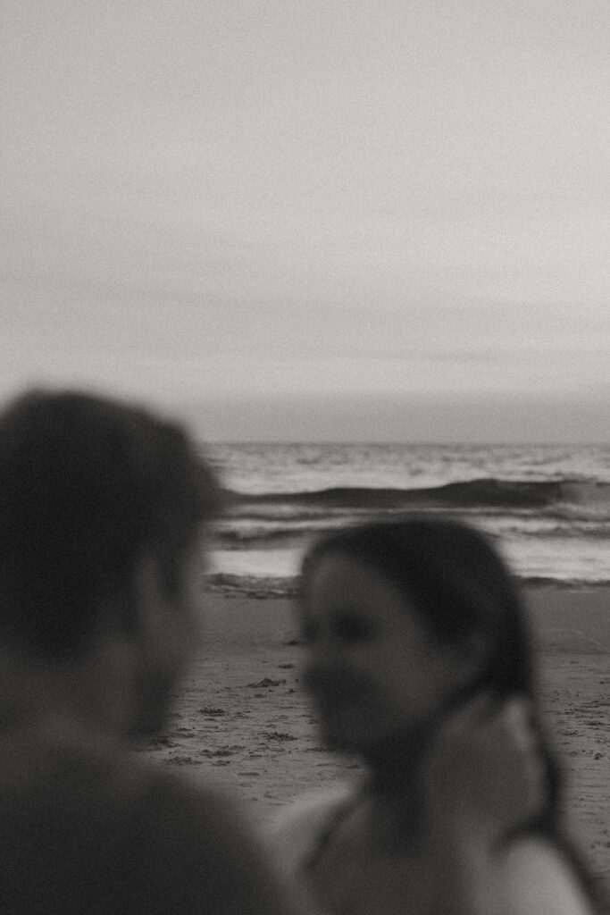 romantic photo captured during a Michigan engagement session with the stunning lake waves in the background