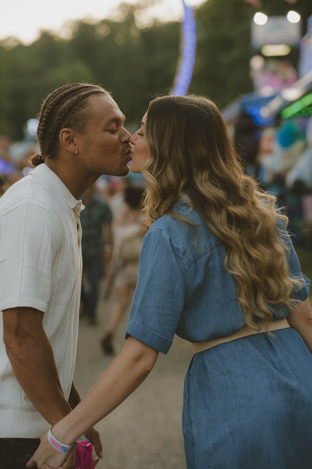 couple share a kiss during their fun couples photos at the state fair in Michigan