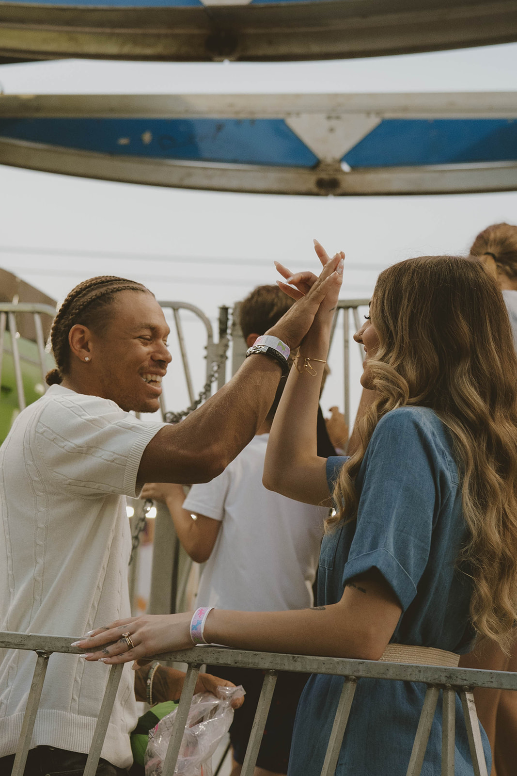 couple high five and share deep laughs during their state fair fun couples photos