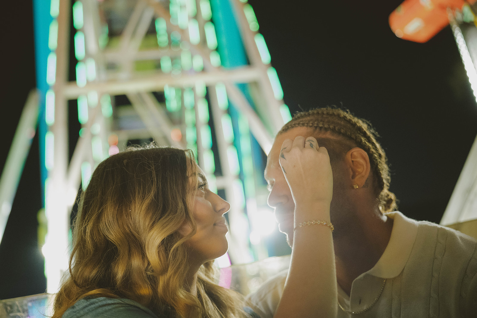 couple share an intimate moment by the ferris wheel
