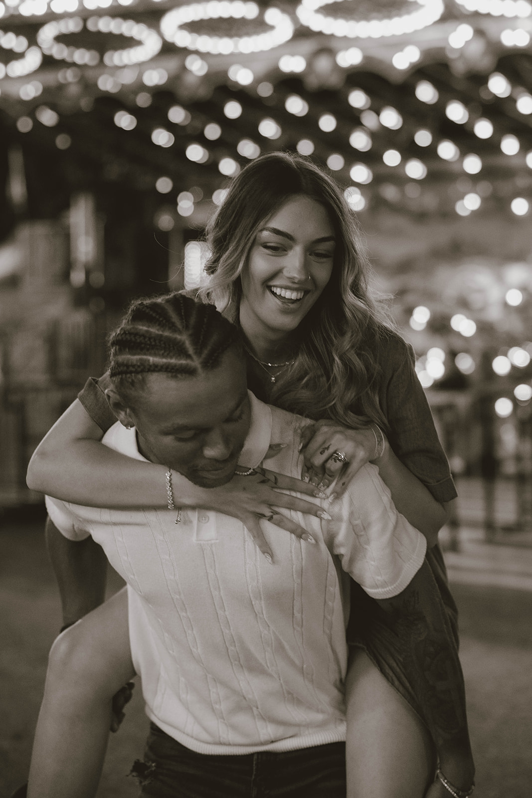 boyfriend gives his girlfriend a piggy back ride at the state fair during their fun couples photos
