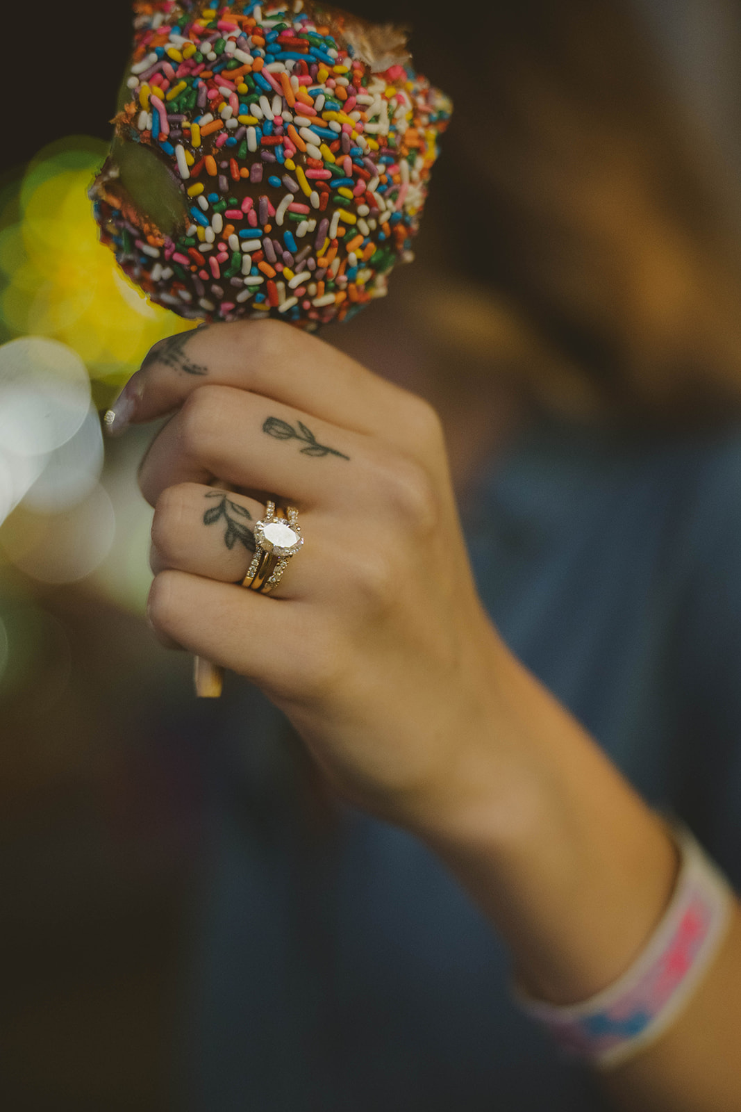 girl holds a sprinkle covered caramel coated apple