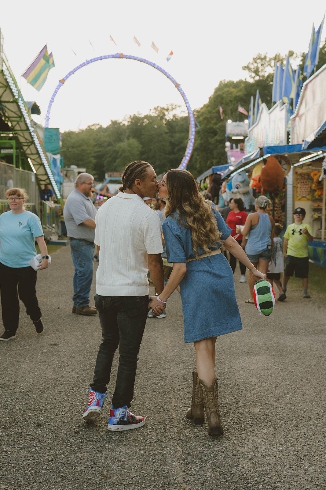 couple share a kiss during their fun couples photos at the state fair in Michigan