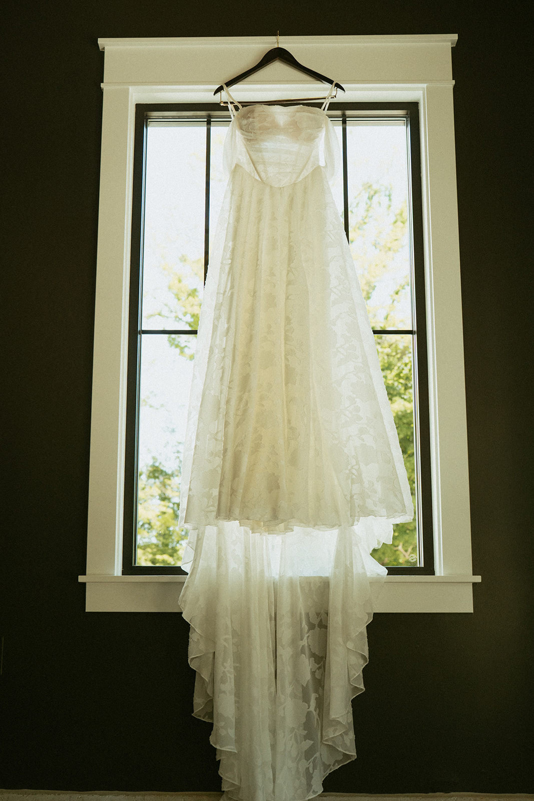 brides dress hangs on the stunning classic window