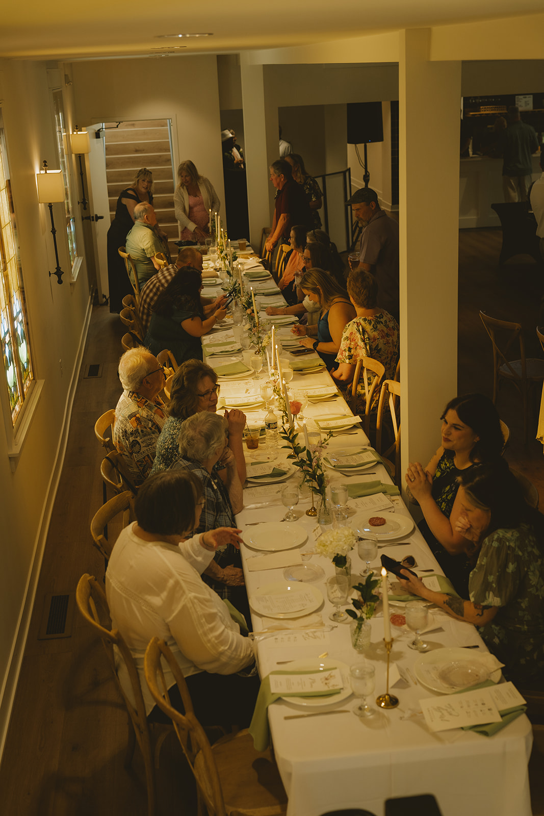 candid wedding reception photo captures the guests sitting at the table