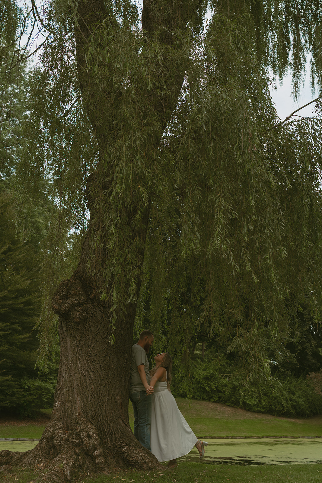 couple lean against the tree during their Michigan engagement session